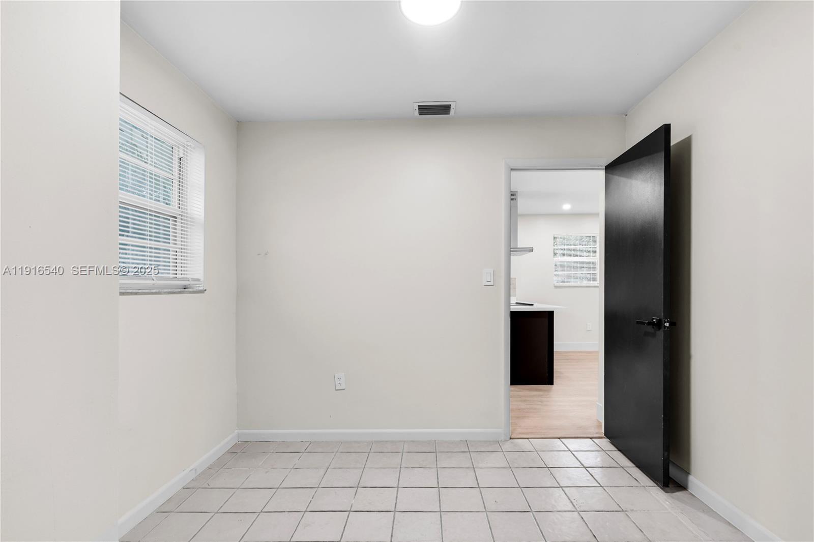1253 Northwest 44th Street Miami, FL 33142 - Photo 9 of 25 a view of an empty room with window and cabinet