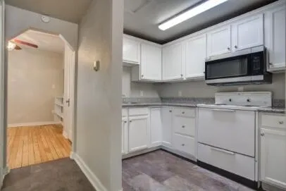 a kitchen with white cabinets and white appliances