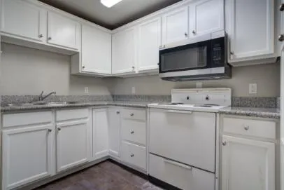 a kitchen with granite countertop white cabinets and a sink