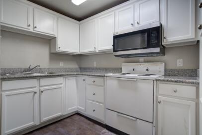 2305 14th Street, Unit B Lubbock, TX 79401 - Photo 14 of 14 a kitchen with granite countertop white cabinets and a sink