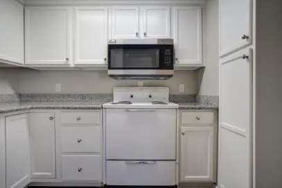 a kitchen with granite countertop white cabinets and a sink