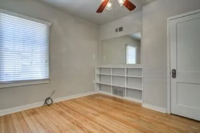 an empty room with cabinet and wooden floor