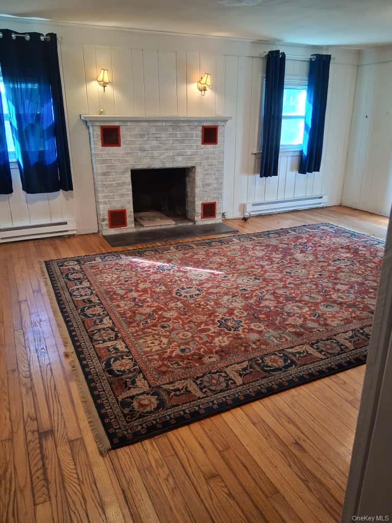 152 Forest Glen Road, Unit 4 New Paltz, NY 12561 - Photo 6 of 12 a view of a livingroom with wooden floor and a fireplace