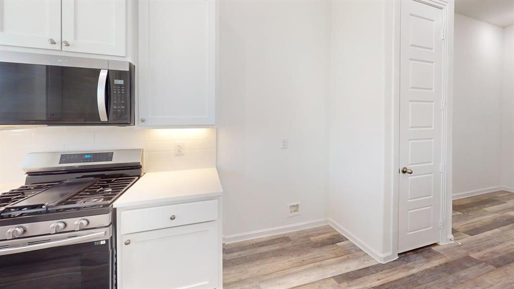 285 Buck Ridge Drive Little Elm, TX 75068 - Photo 5 of 20 a kitchen with a stove and a microwave