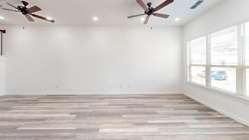 285 Buck Ridge Drive Little Elm, TX 75068 - Photo 8 of 20 an empty room with wooden floor fan and windows