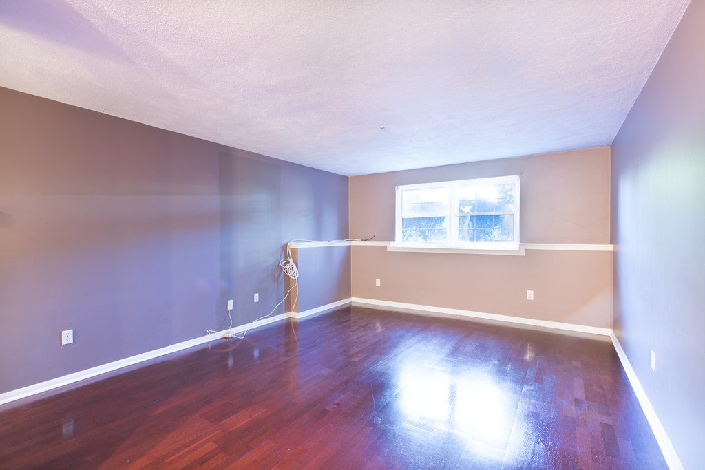 360 Neponset Street, Unit 702 Canton, MA 02021 - Photo 2 of 6 a view of an empty room with wooden floor and a window