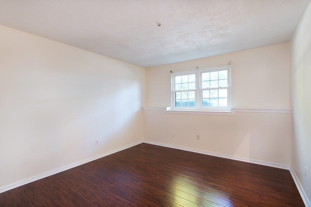 360 Neponset Street, Unit 702 Canton, MA 02021 - Photo 4 of 6 an empty room with wooden floor and windows