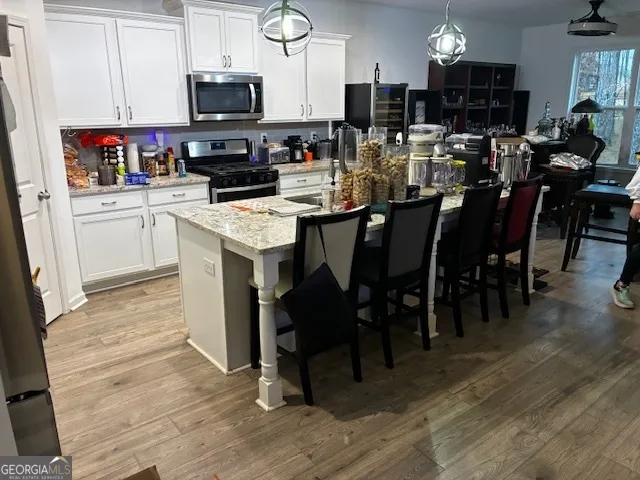 a kitchen with a dining table chairs and flat screen tv