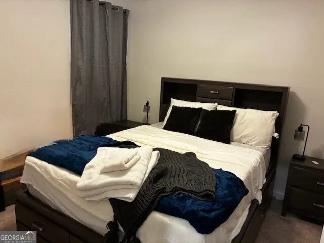 a bedroom with a bed and a night stand