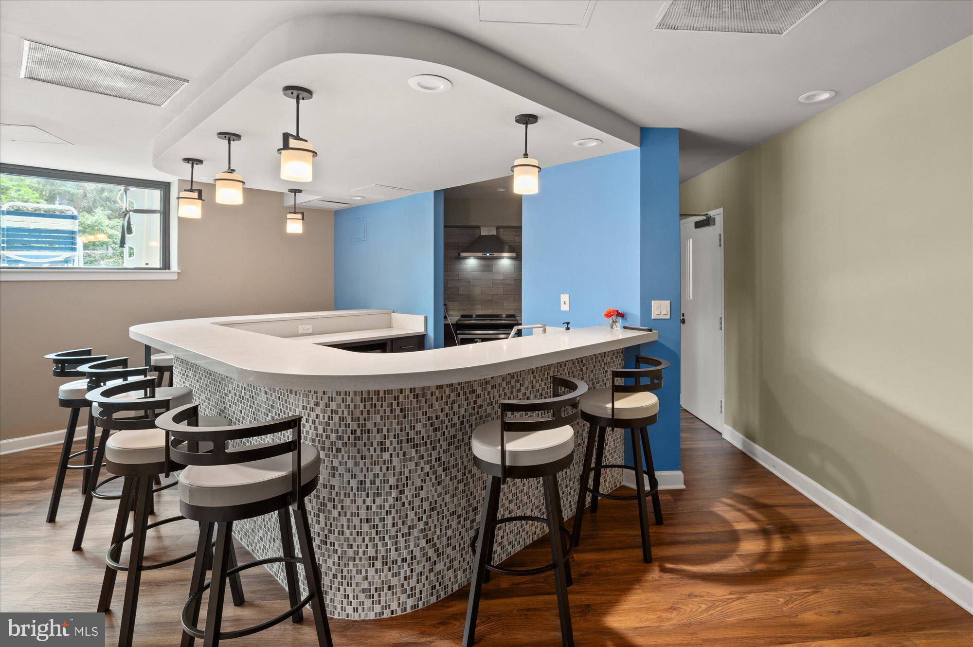 2111 Wisconsin Avenue Northwest, Unit 606 Washington, DC 20007 - Photo 14 of 22 a kitchen with a table chairs a sink dishwasher and wooden floor