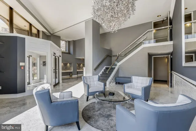 a living room with couches chairs and kitchen view