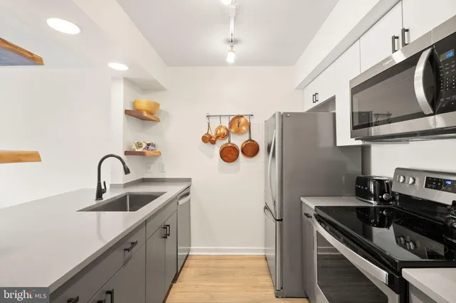 a kitchen with stainless steel appliances granite countertop a sink and a refrigerator