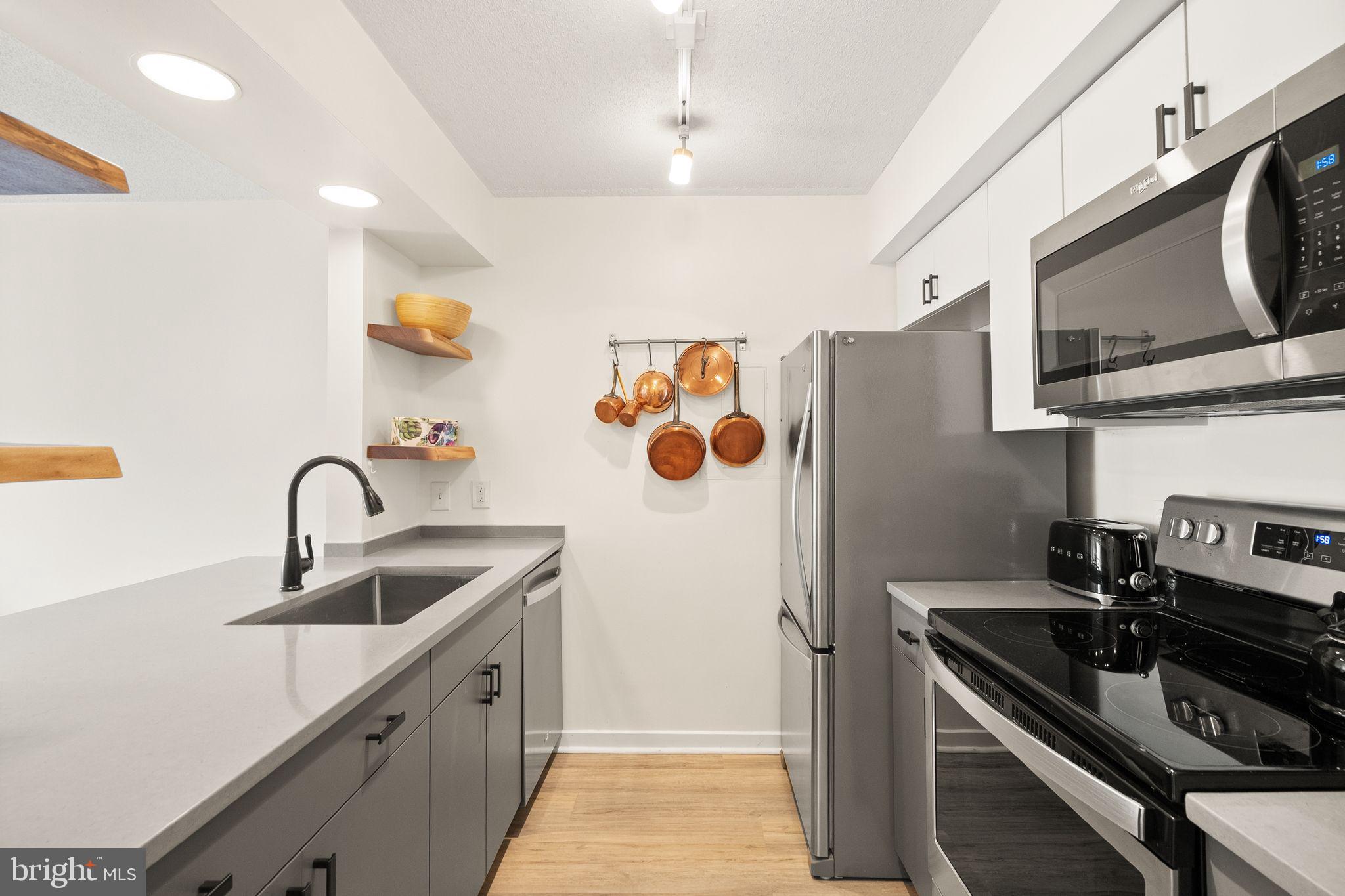 2111 Wisconsin Avenue Northwest, Unit 606 Washington, DC 20007 - Photo 4 of 22 a kitchen with stainless steel appliances granite countertop a sink and a refrigerator