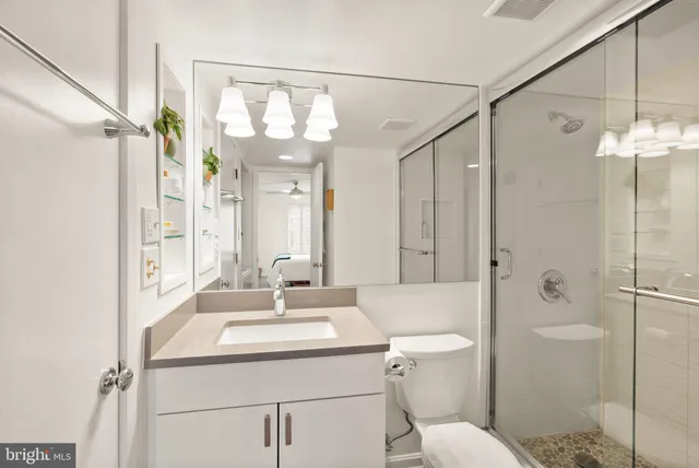 a bathroom with a sink toilet vanity and shower