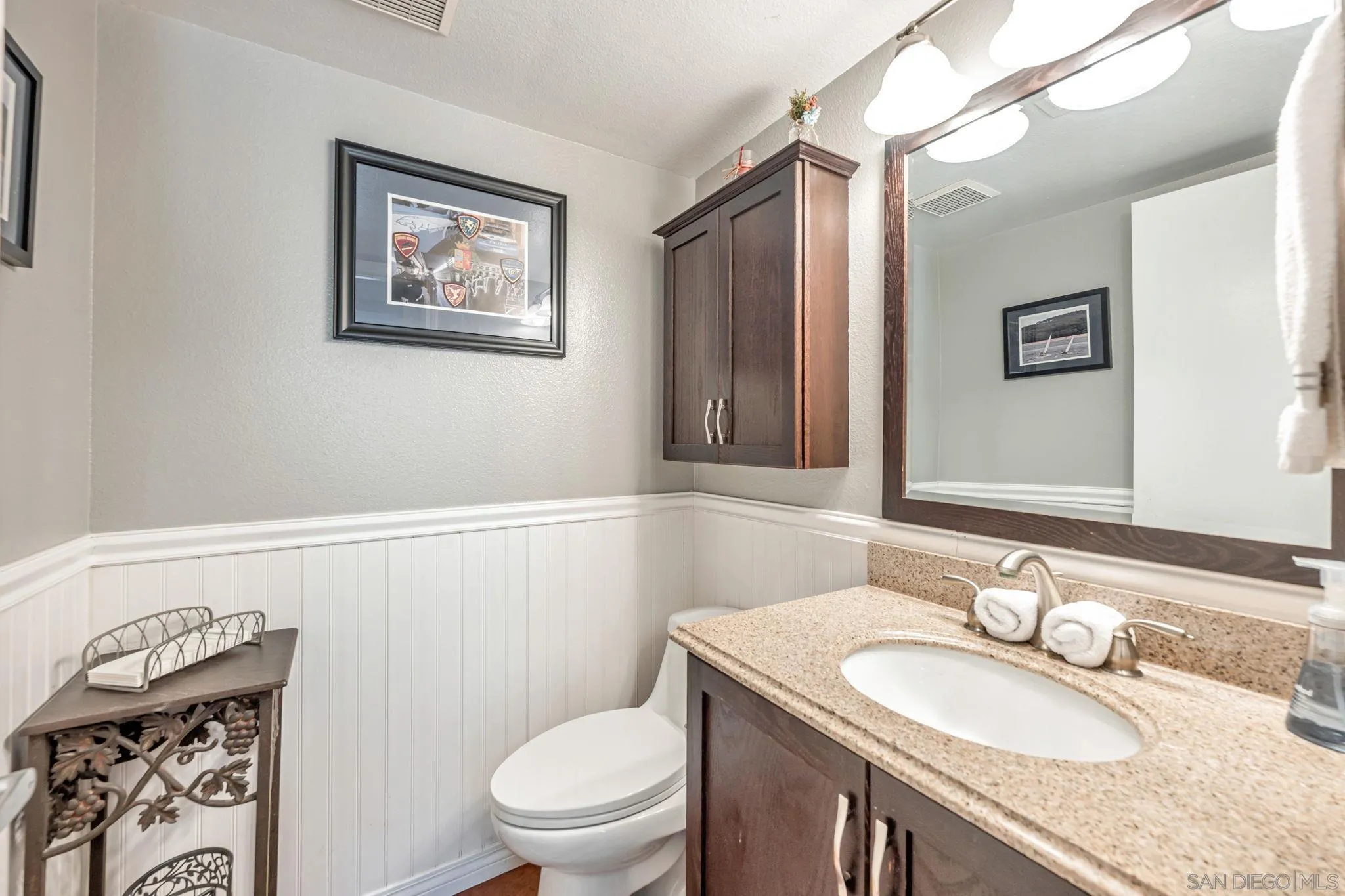 3304 Del Charro Road Jamul, CA 91935 - Photo 29 of 44 a bathroom with a granite countertop toilet a sink and a mirror