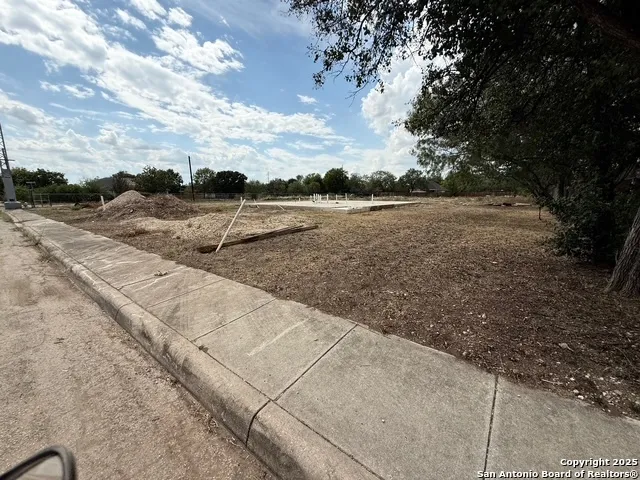 a view of a dry yard with wooden fence