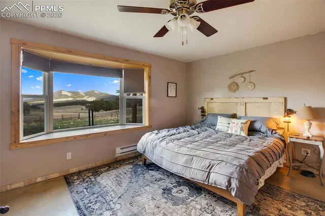 a bedroom with a large bed and a chandelier fan