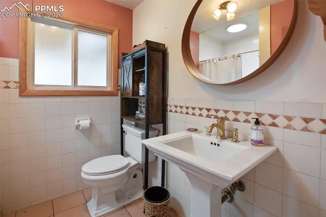 a bathroom with a sink a toilet and a mirror
