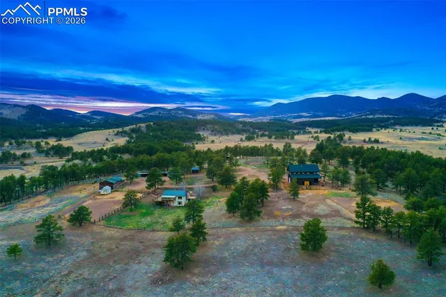 a view of a town with swimming pool and mountains in the background