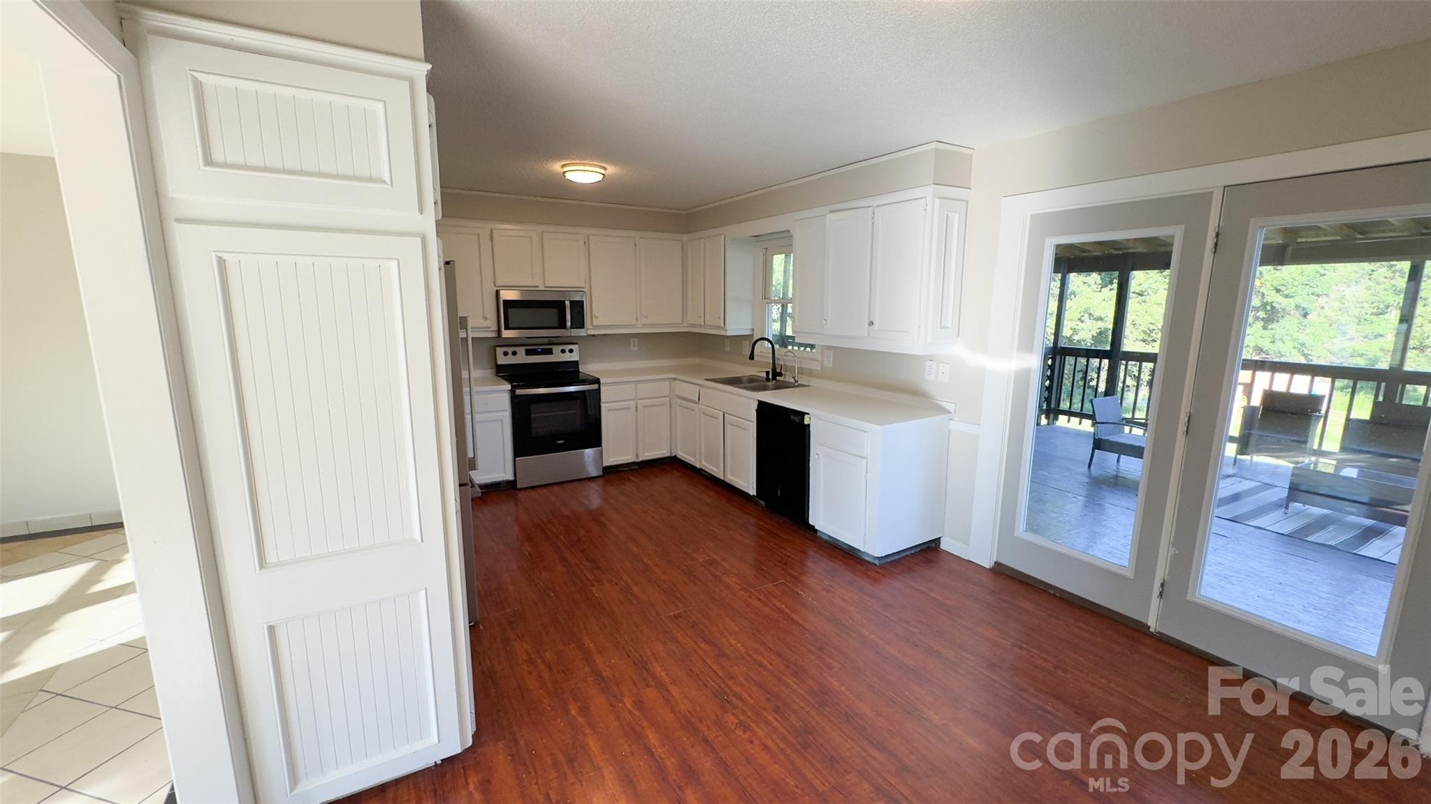 3014 Morgan Mill Road Monroe, NC 28110 - Photo 5 of 26 a kitchen with white cabinets and wooden floor