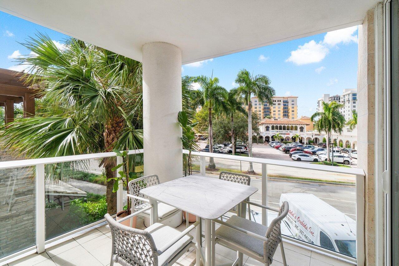200 Southeast Mizner Boulevard, Unit 211 Boca Raton, FL 33432 - Photo 14 of 67 a view of a chairs and table in patio with a yard