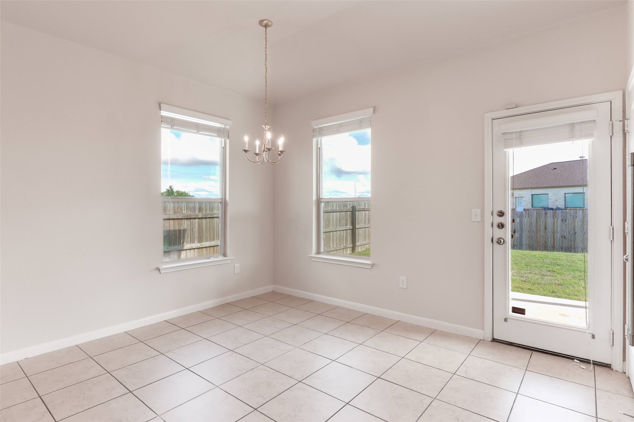 18705 Moreto Loop Pflugerville, TX 78660 - Photo 8 of 21 A well-lit eating area featuring tile flooring and a view of the fenced backyard.