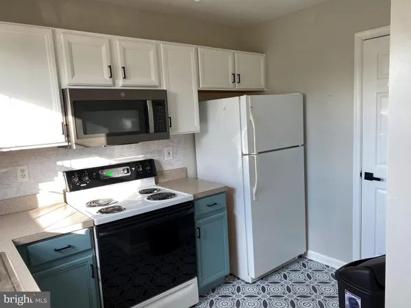 a kitchen with appliances a microwave and cabinets