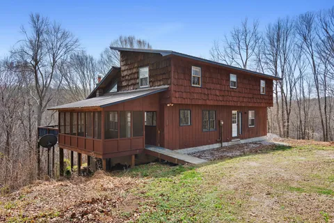 a view of a house with a yard and wooden fence