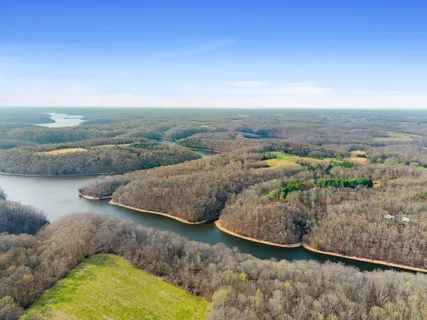 an aerial view of a house with a yard and lake view