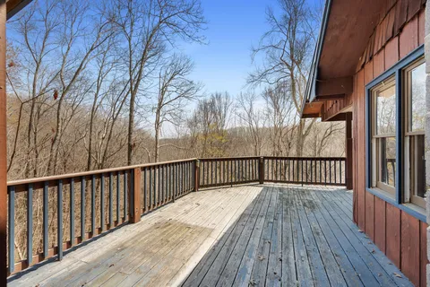 a balcony with wooden floor and trees