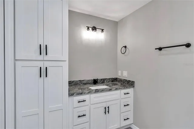 a bathroom with a granite countertop sink and a mirror