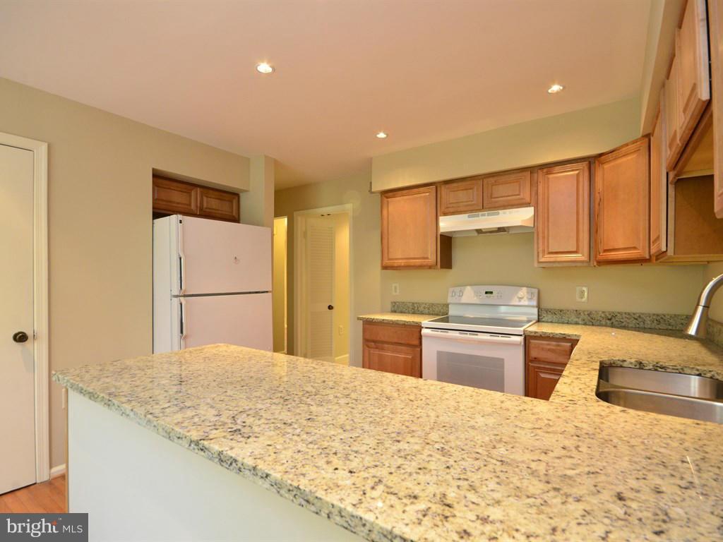 17 Pebble Ridge Court Potomac, MD 20854 - Photo 11 of 29 a kitchen with stainless steel appliances granite countertop a sink refrigerator and cabinets