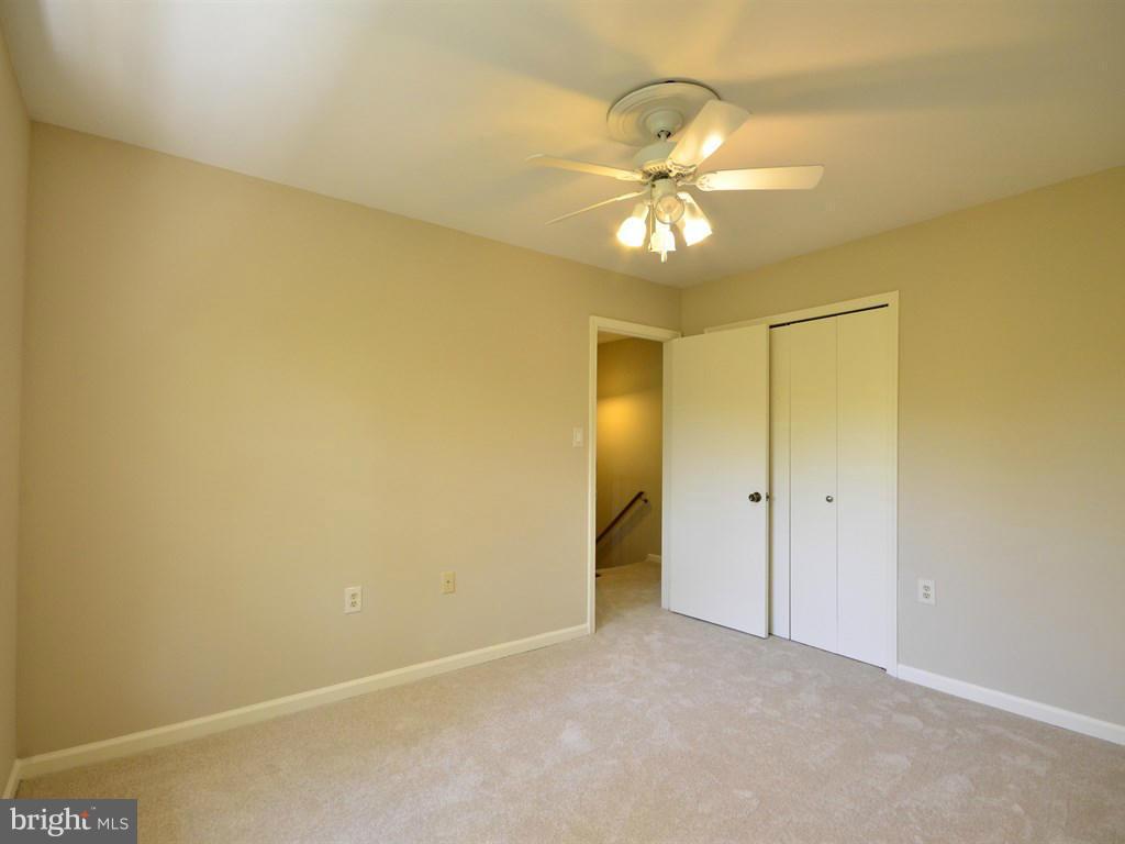 17 Pebble Ridge Court Potomac, MD 20854 - Photo 20 of 29 an empty room with a chandelier fan and a closet