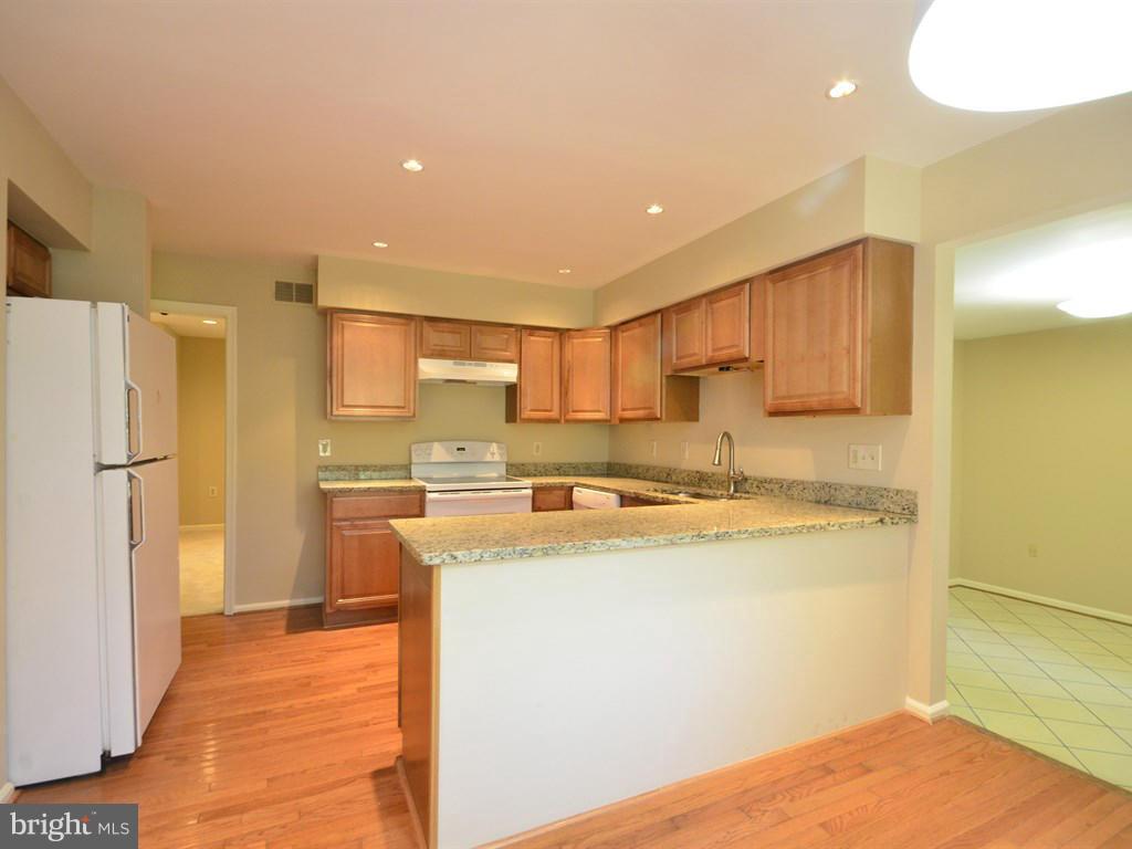 17 Pebble Ridge Court Potomac, MD 20854 - Photo 9 of 29 a kitchen with stainless steel appliances granite countertop a refrigerator a stove and a sink