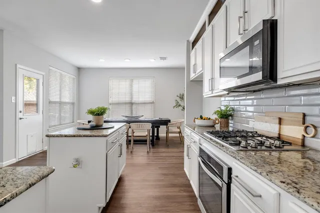 a kitchen with stainless steel appliances a sink stove and cabinets