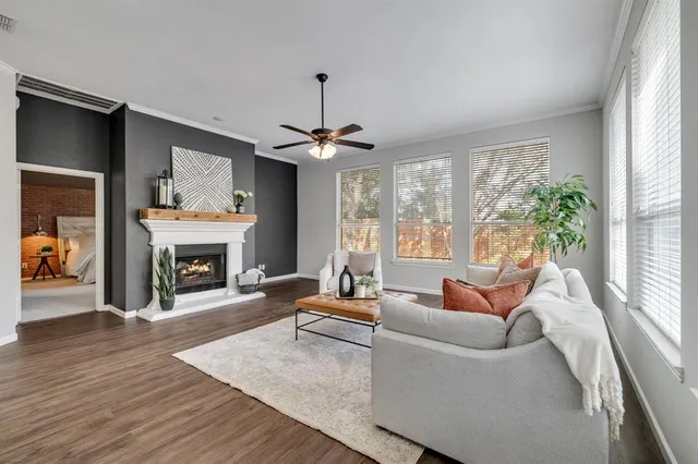 a living room with furniture a fireplace and a large window
