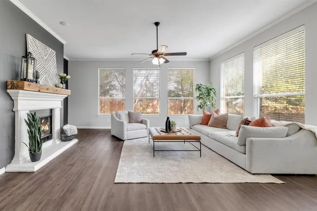 a living room with furniture a fireplace and a large window