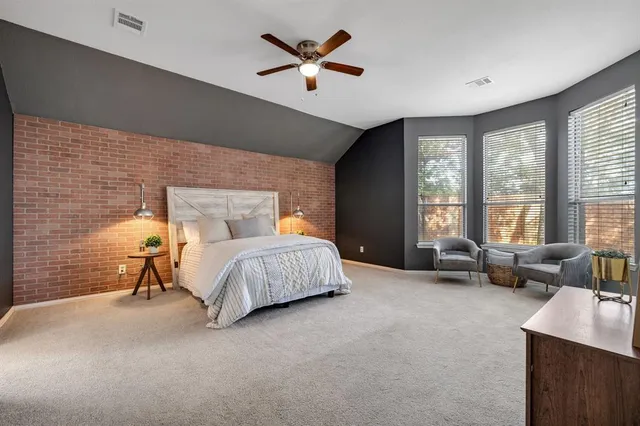 a bedroom with a bed and a large window