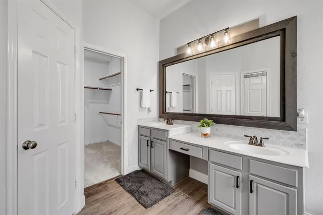 a bathroom with a double vanity sink mirror and shower