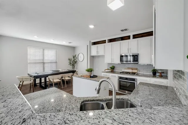 a kitchen with a stove a sink a counter top space and cabinets