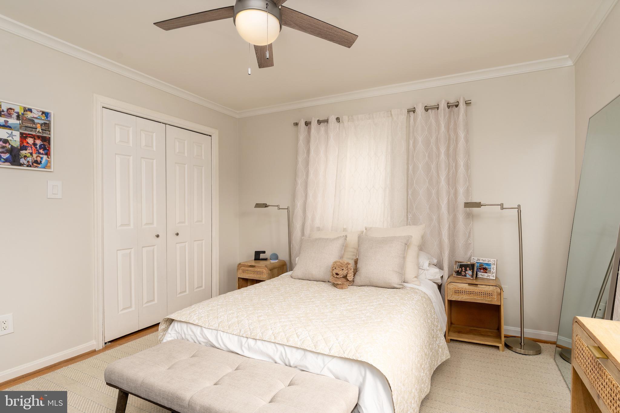 5050 Bradley Boulevard, Unit 6 Chevy Chase, MD 20815 - Photo 14 of 25 a bedroom with a bed and a chandelier