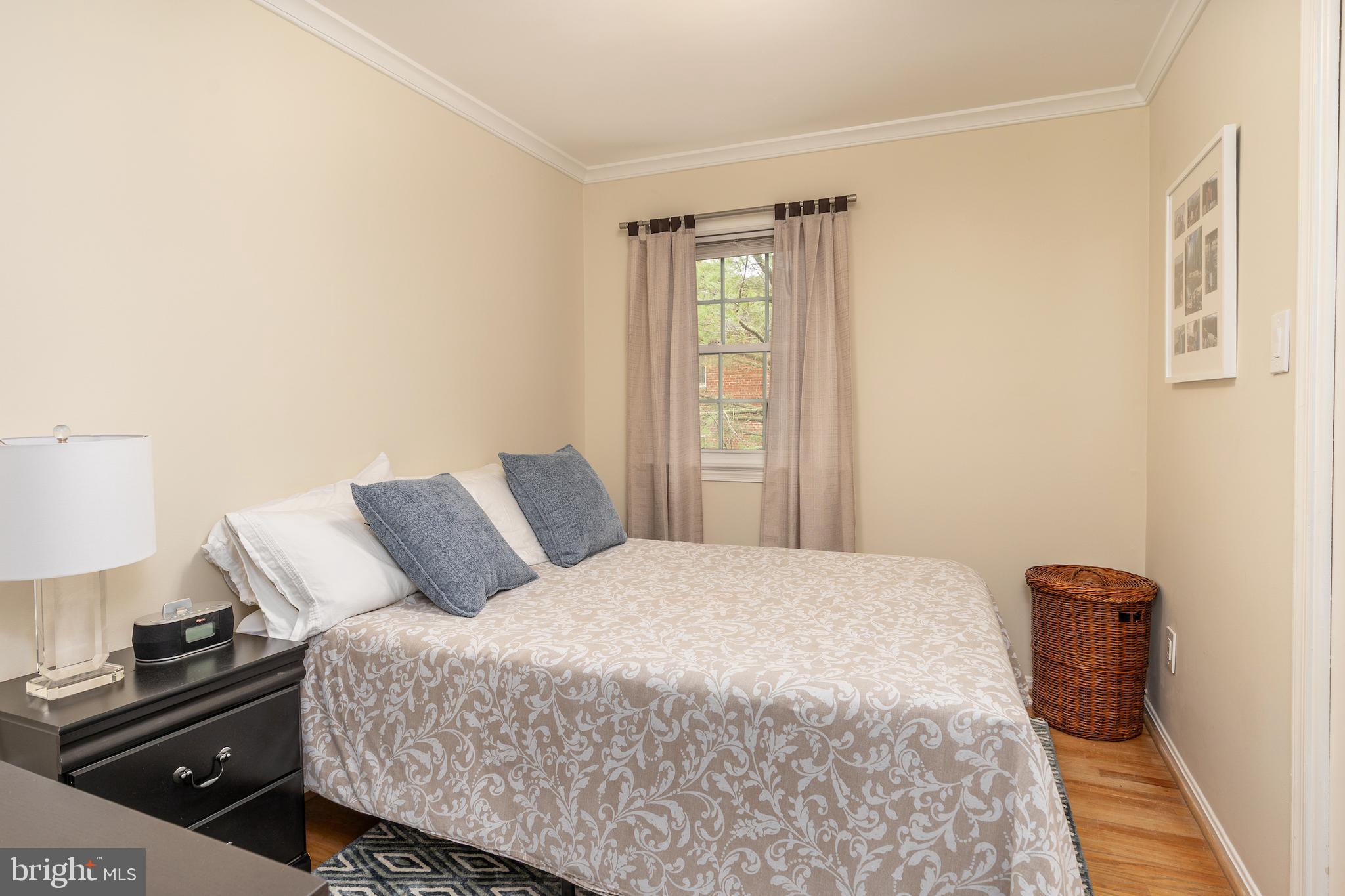 5050 Bradley Boulevard, Unit 6 Chevy Chase, MD 20815 - Photo 18 of 25 a bedroom with a bed and a lamp on dresser
