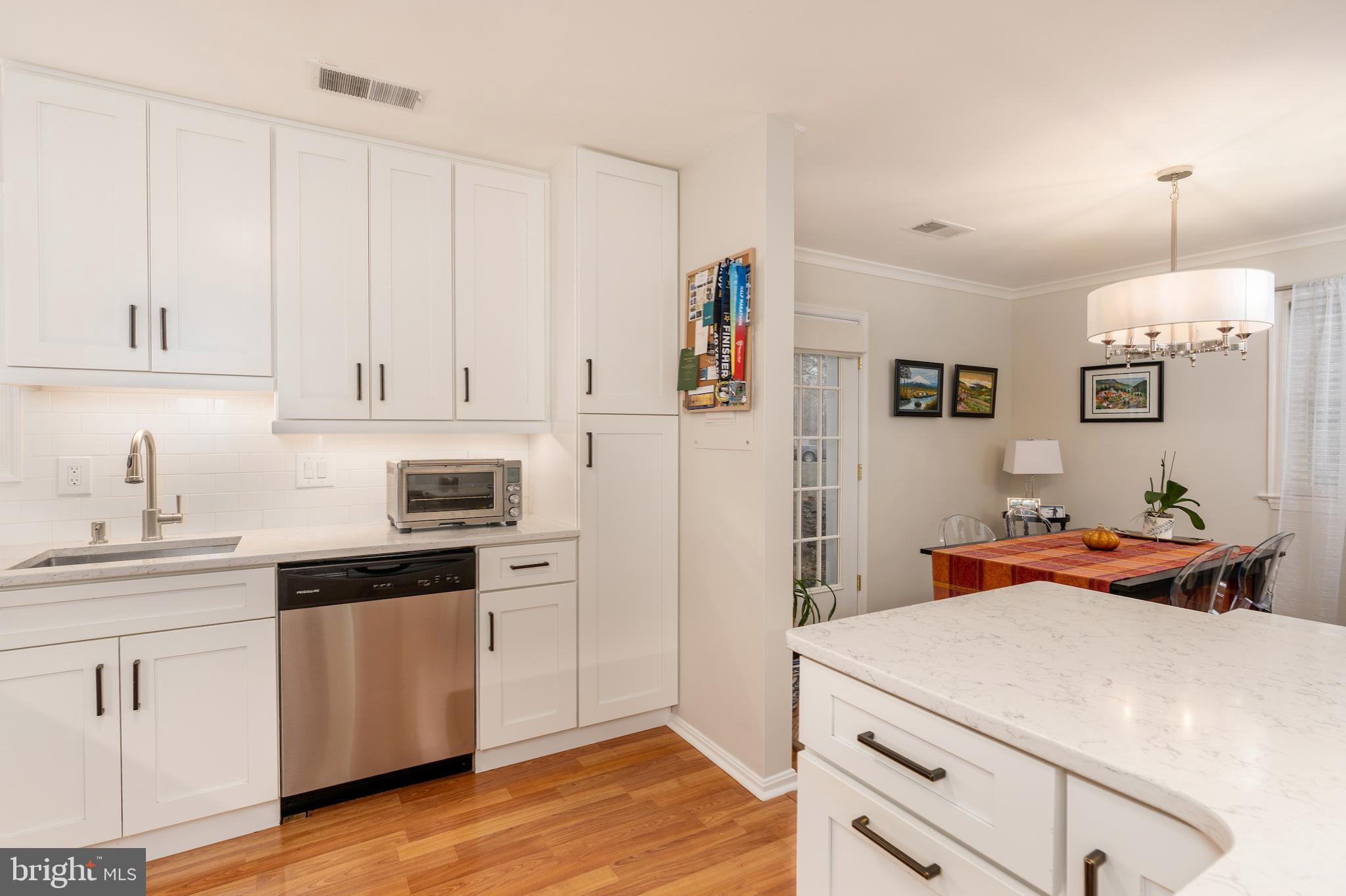5050 Bradley Boulevard, Unit 6 Chevy Chase, MD 20815 - Photo 7 of 25 a kitchen with stainless steel appliances a white cabinets and wooden floor