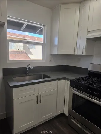 a kitchen with granite countertop white cabinets and black appliances