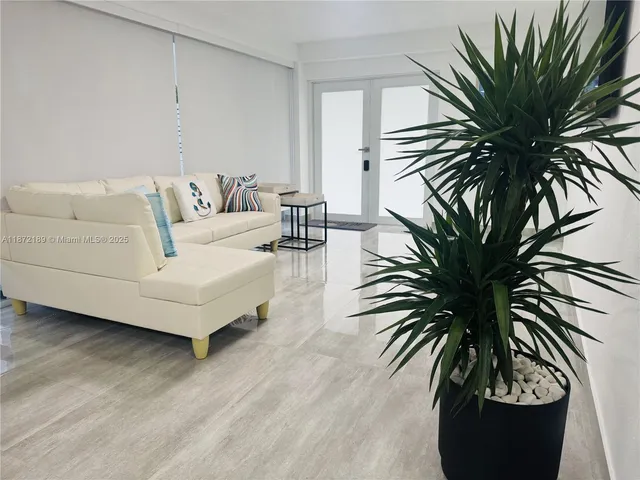 a living room with furniture and a potted plant