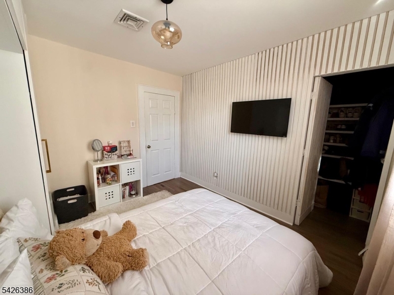 195 Maple Street Kearny, NJ 07032 - Photo 12 of 24 a bedroom with a bed and a flat screen tv