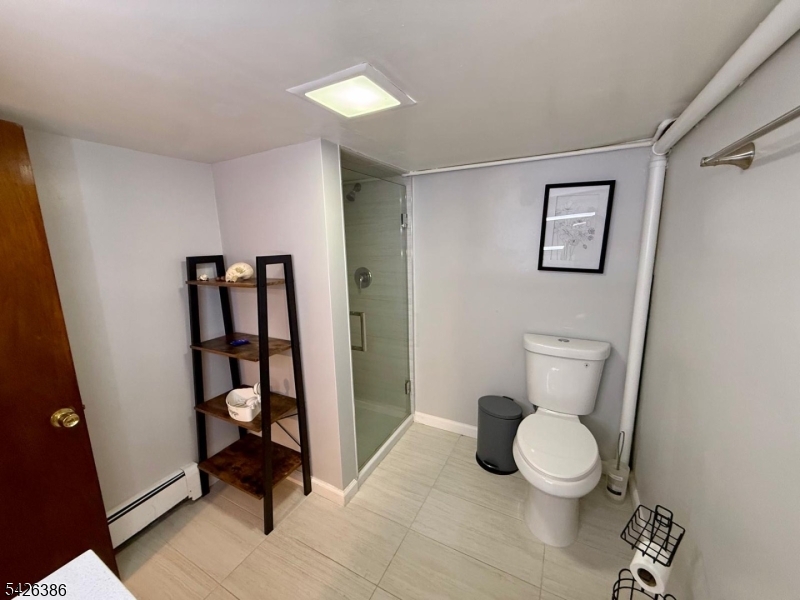 195 Maple Street Kearny, NJ 07032 - Photo 16 of 24 a white toilet sitting next to a bathroom sink and vanity