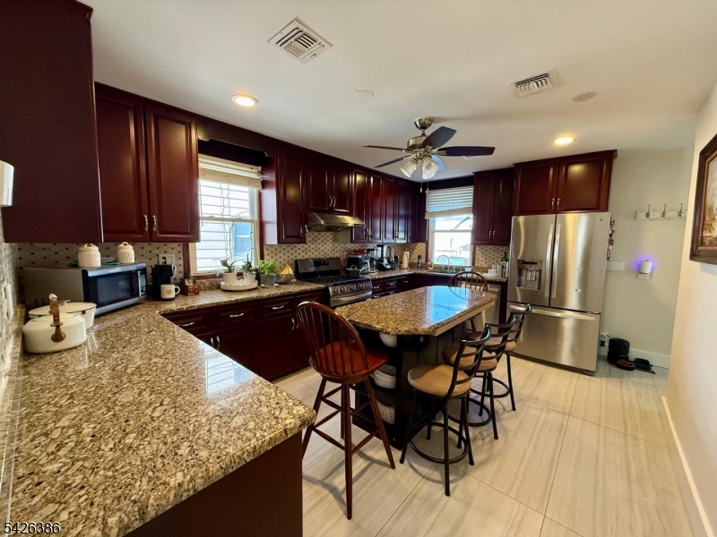 195 Maple Street Kearny, NJ 07032 - Photo 4 of 24 a kitchen with stainless steel appliances granite countertop sink stove refrigerator and cabinets