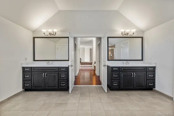 a spacious bathroom with a vanity a sink a mirror and a bathtub
