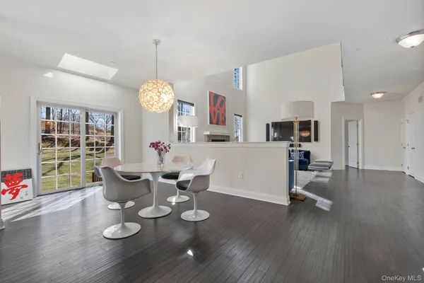 a dining room with wooden floor a chandelier a wooden table and chairs